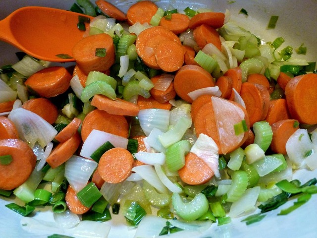 Sliced carrots, celery, leeks, and a bit of onion cooking over gentle heat